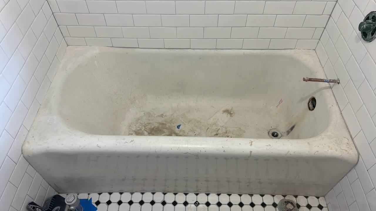 Outdated yellowish bathtub with visible stains and wear before restoration in Los Angeles home
