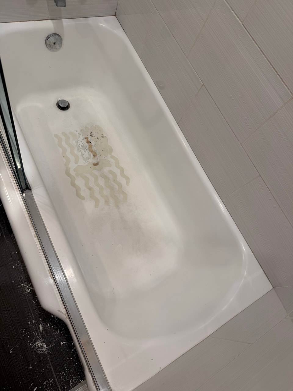 Worn patches on the bathtub floor before the Manhattan Beach project