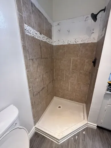 Old pink bathroom tiles with dirty grout lines before refinishing